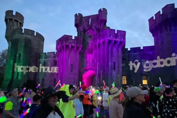 a castle lit up with runners and glowsticks and ty gobaith logo