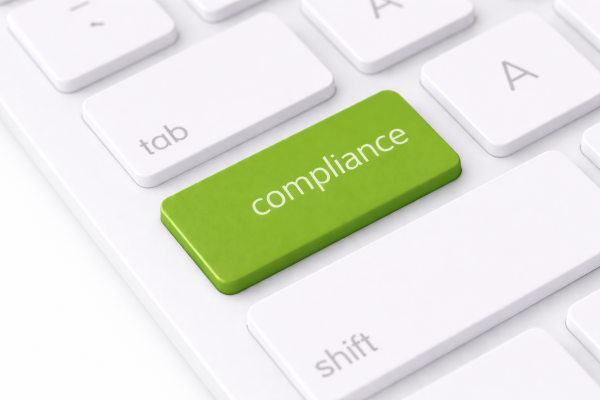 a green button on a white keyboard which reads "compliance