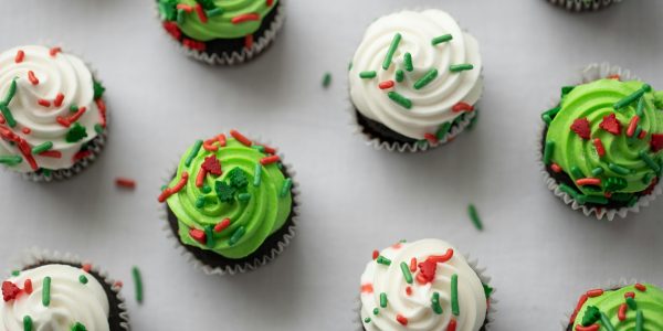 Green and white iced cupcakes from above with sprinkles on